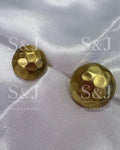Botão metálico dourado com textura martelada e acabamento fosco
